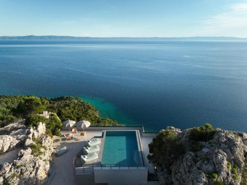 an aerial view of a house on a cliff with a swimming pool at Kuk Oaza Luxury Villas in Makarska