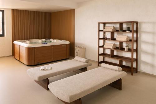 a bathroom with a bath tub and two benches at Kuk Oaza Luxury Villas in Makarska