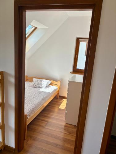 a small bedroom with a bed and a window at Domek Buflak in Nowy Targ