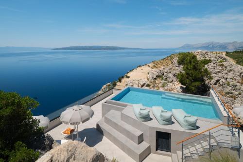 a swimming pool with a view of the water at Kuk Oaza Luxury Villas in Makarska