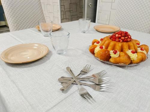 a table with a table cloth with a cake and forks at TIVA' Holiday House in Pozzuoli