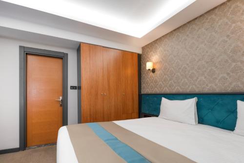 a bedroom with a bed and a wooden door at Fier Life Center in Kayseri