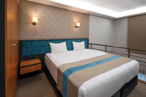 a bedroom with a large bed with a blue headboard at Fier Life Center in Kayseri