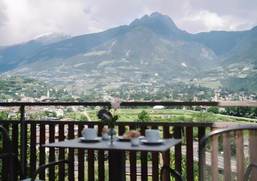 a table with two cups on it with a view of a mountain at Ferienappartement Freiblick in Marlengo