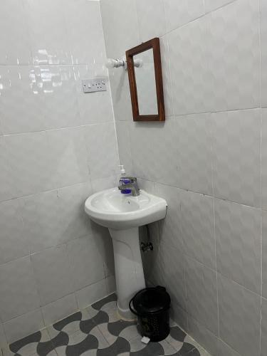 a bathroom with a white sink and a mirror at Reef 2Nungwi House in Nungwi