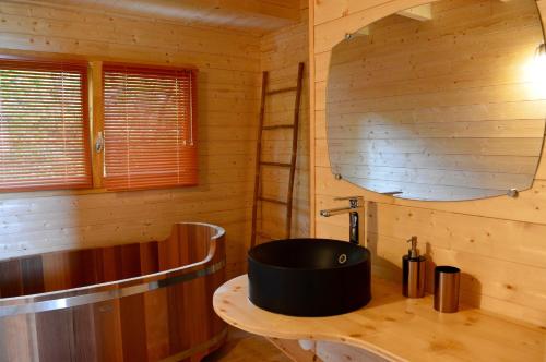 - une salle de bains pourvue d'un lavabo rond dans une cabane en bois dans l'établissement Les Lodges Du Reynou, à Le Vigen