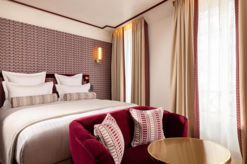 a hotel room with a bed and a table at Hôtel Filigrane & Spa in Paris