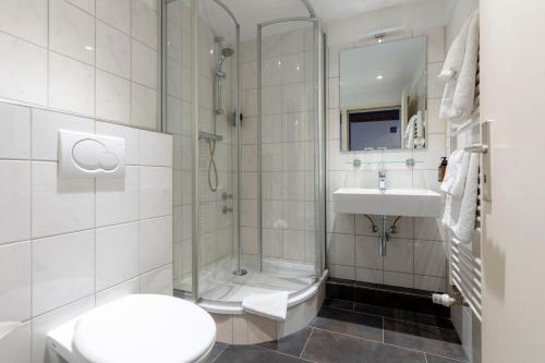 a bathroom with a shower and a sink and a toilet at Auto-Parkhotel Hamburg St Pauli in Hamburg