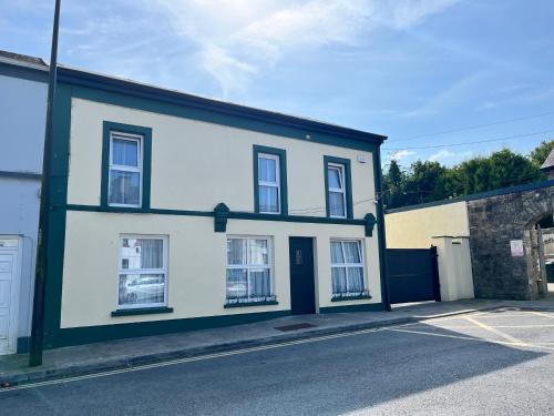 a white house with black trim on a street at The Old Post Office, Dunmore in Dunmore