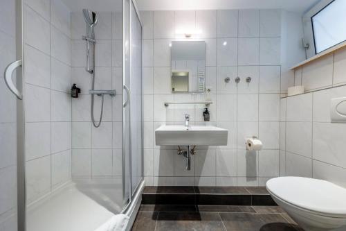 a bathroom with a shower and a sink and a toilet at Auto-Parkhotel Hamburg St Pauli in Hamburg
