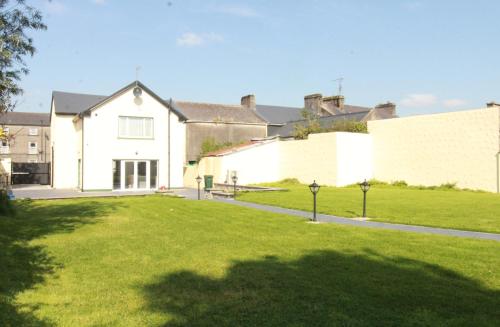 a large white house with a grass yard at The Old Post Office, Dunmore in Dunmore