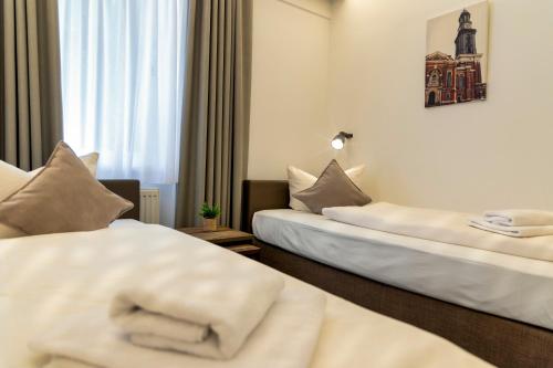 a hotel room with two beds and a window at Auto-Parkhotel Hamburg St Pauli in Hamburg