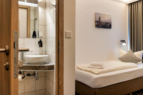 a small bathroom with a bed and a sink at Auto-Parkhotel Hamburg St Pauli in Hamburg