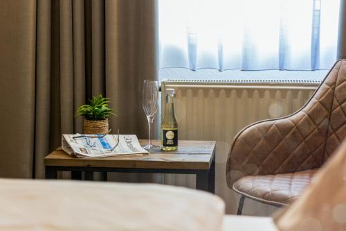 a table with a bottle of wine and a glass at Auto-Parkhotel Hamburg St Pauli in Hamburg