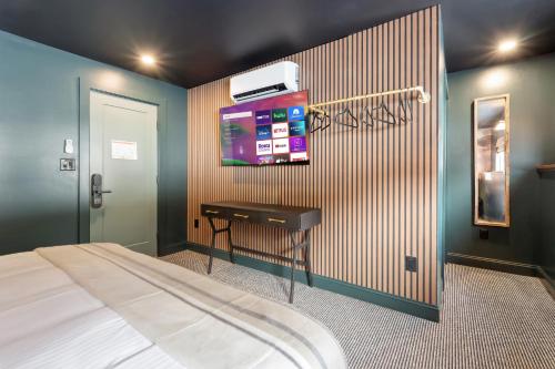 a bedroom with a bed and a tv on the wall at Inn At Mount Snow in West Dover
