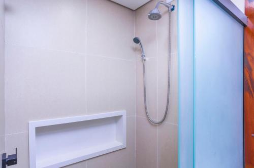 a bathroom with a shower with a shower head at Hotel Village Enseada in Ubatuba