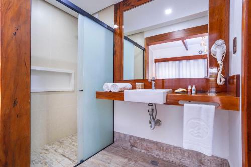 a bathroom with a sink and a mirror at Hotel Village Enseada in Ubatuba