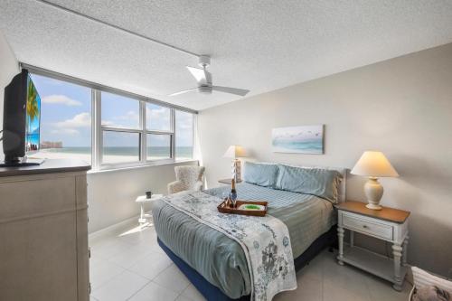a bedroom with a bed and a window at SW facing beachfront condo with sweeping ocean views in Marco Island
