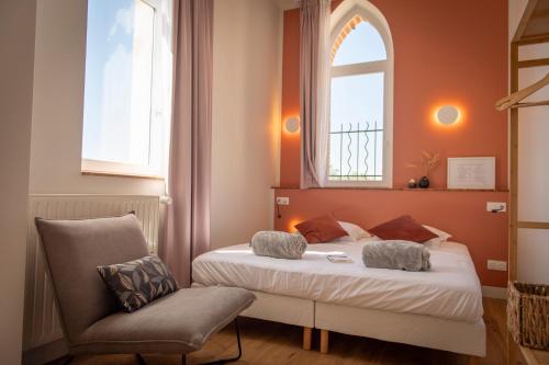 a bedroom with a bed and a chair and a window at Hotellerie de l'Abbaye du Désert in Bellegarde