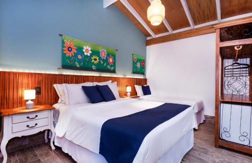 a bedroom with a large white bed and a window at Hotel Village Enseada in Ubatuba
