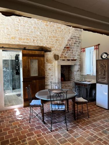 a kitchen with a table and chairs in a room at Le grenier d'Odette in Sainte-Gemme-la-Plaine
