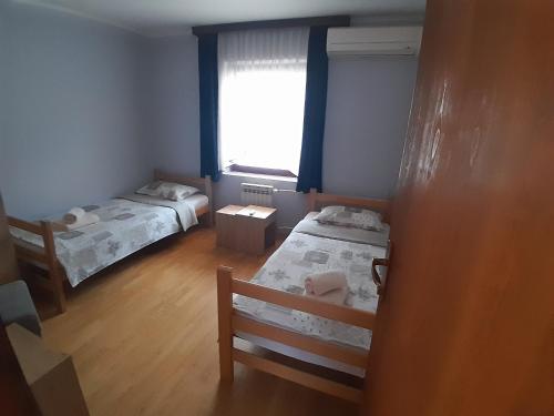 a small room with two beds and a window at LM 19 in Novi Sad