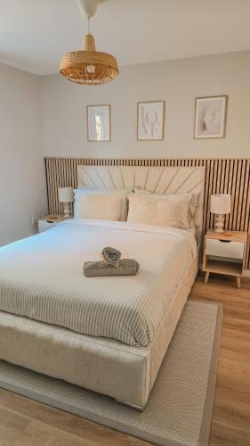 a bedroom with a large bed with a wooden headboard at Welcome Home in Royston