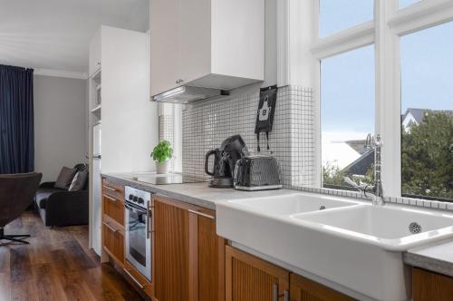 a kitchen with a sink and a stove and a window at Berg Apartments in Reykjavík