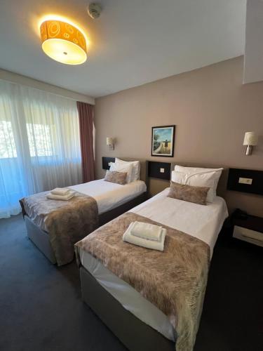 a hotel room with two beds in a room at Garden City Hotel Konjic in Konjic