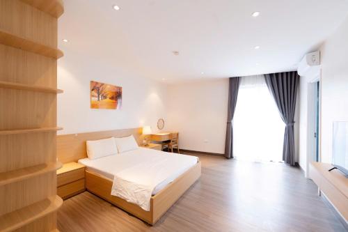 a bedroom with a bed and a desk in it at Chuỗi Homestay Bãi Cháy Hạ Long in Ha Long