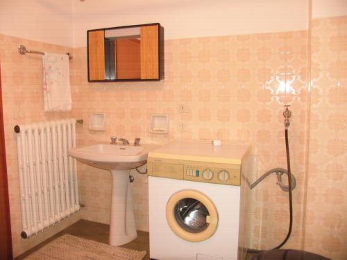 a bathroom with a washing machine and a sink at Al Viandante Casa Rosa in Sitran