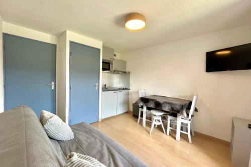 a living room with a table and a dining room at Au Pied des Neiges in Demi-Quartier