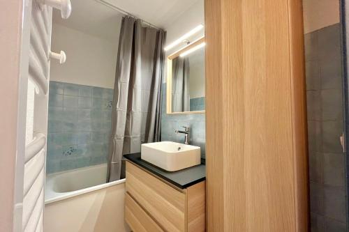 a bathroom with a sink and a bath tub at Au Pied des Neiges in Demi-Quartier