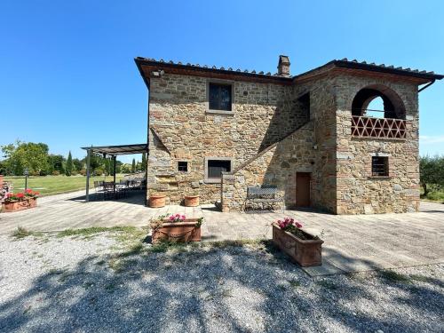 a large stone building with a patio with flowers at Villa Manciano in Marciano