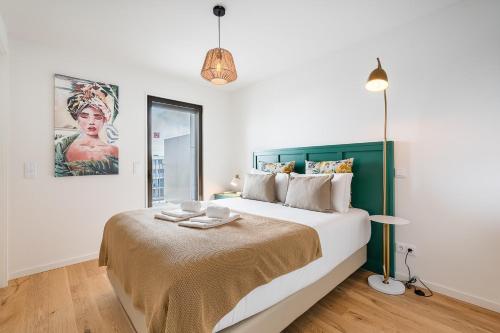 a bedroom with a large bed with a green headboard at GuestReady - Splendid Retreat in Porto in Porto
