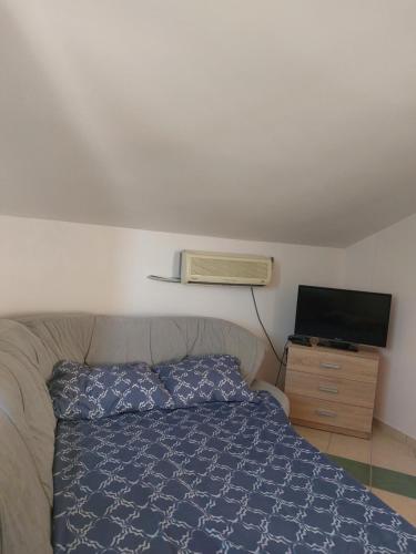 a bedroom with a bed and a flat screen tv at APARTMANI IGERČIĆ in Stinica