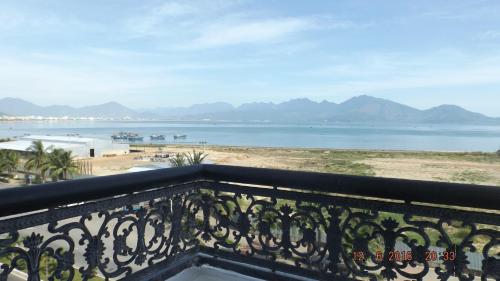 a balcony with a view of the beach and mountains at Rosa Bayside Guesthouse in Da Nang