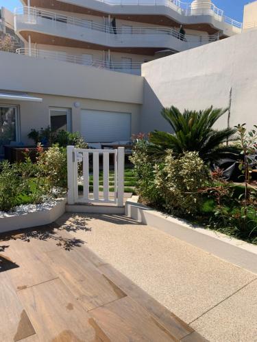 a white gate in front of a building at Cap Neree Petit coin de paradis pieds dans l eau in Saint-Raphaël