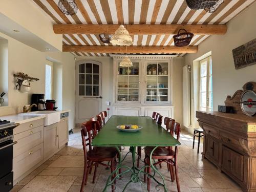 a kitchen with a green table and chairs at Villa spacieuse avec jardin à Saignon in Saignon