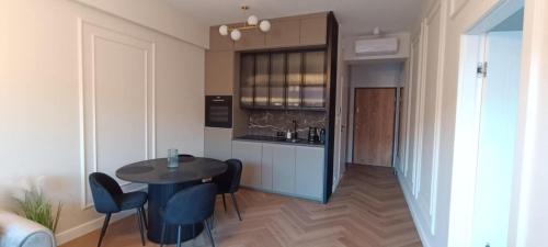 a kitchen with a table and chairs in a room at Masuria Apartaments Ełk Centrum in Ełk