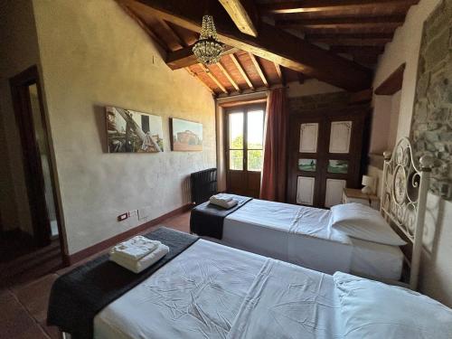 a bedroom with two beds and a chandelier at Villa Manciano in Marciano
