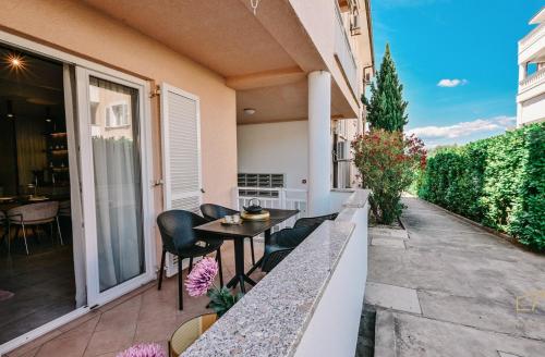 a balcony with a table and chairs on a building at Deluxe Apartment Malin 3 near the beach in Vantačići