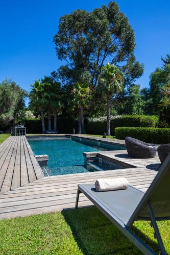- une piscine avec une table et une chaise dans la cour dans l'établissement Luxueuse Villa vue mer avec piscine Golfe de St Tropez 14 personnes, à Grimaud