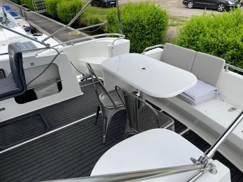 a deck of a boat with chairs and a table at Magnifique bateau au coeur du Nivernais à l'étang de BAYE in Bazolles