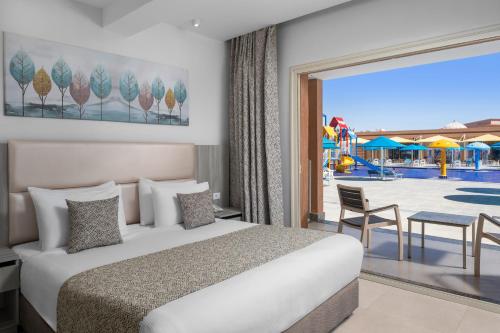 a bedroom with a bed and a view of a pool at Pickalbatros Jungle Aqua Park - Neverland Hurghada in Hurghada