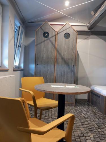a table and chairs in a room with a door at Kloster Bonlanden in Berkheim