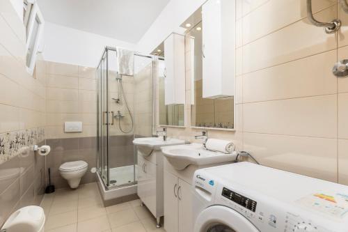 a white bathroom with a washing machine in it at Molo Longo - Downtown Apartments in Rijeka