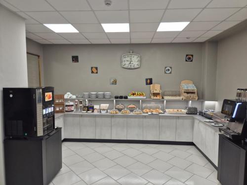 a restaurant with a counter with food on it at Hotel Continental in Turin