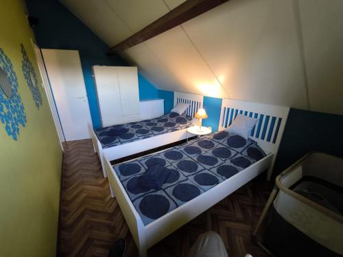 twee bedden in een kleine kamer met blauwe muren bij Maxent aan zee in Middelkerke