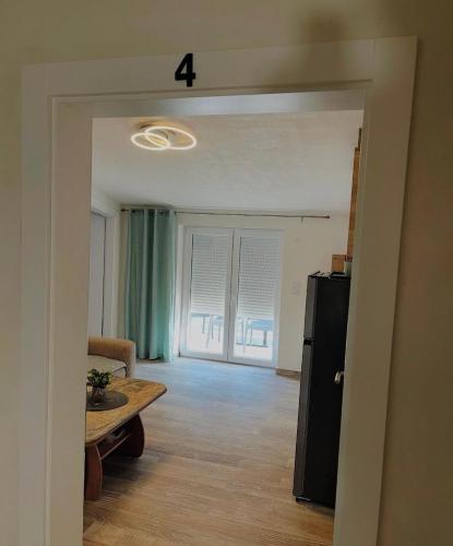 a living room with a table and a refrigerator at Apartments Ravlic in Neum